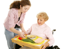 young lady serving a food to an old woman